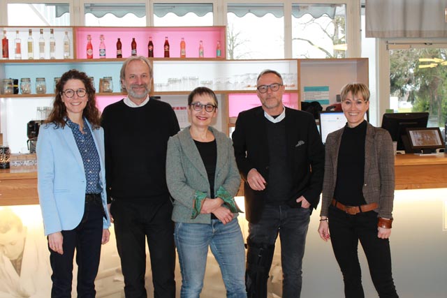 Grossratspräsidentin Elisabeth Burgener (Mitte) mit Marion Wegner-Hänggi (Frau Gemeindeammann Wallbach und Präsidentin WivA Wiedereingliederung von Arbeitslosen im Fricktal), Möhlins Gemeindeammann Markus Fäs, Reto Schaffer (Geschäftsführer der Trinamo AG) und Lea Thüring (Bereichsleiterin der Trinamo AG in Möhlin) vor der Theke des «Bata Club Haus»-Restaurants in Möhlin. Foto: Sonja Fasler