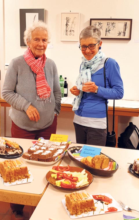 Besucherinnen vor dem Aperotisch mit Aargauer Spezialitäten, dahinter die letzten Werke von Therese Frei-We (japanische Pinselmalereien). Foto: zVg