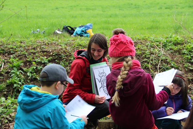 Eine Exkursionsleiterin bei der Führung entlang eines Bachs. Foto: © Jurapark Aargau