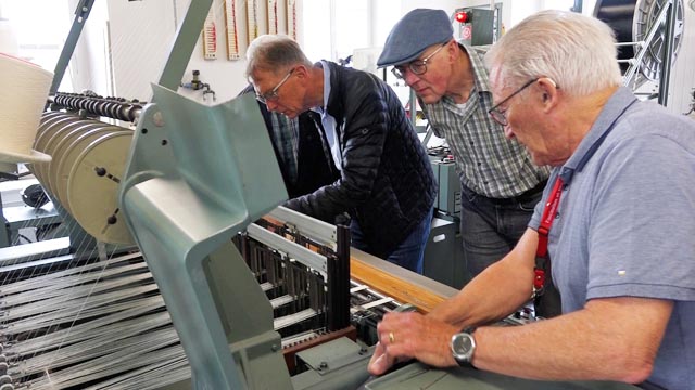 Interessierter Blick in eine Nadelbandwebmaschine. Foto: zVg