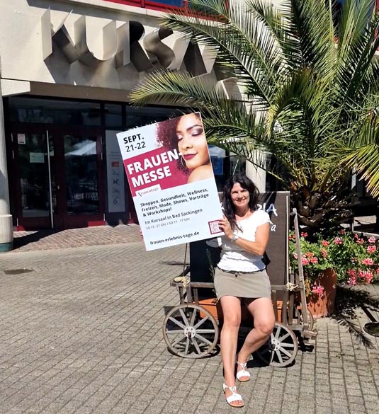 Veranstalterin Anja Inderwildi mit dem «Frauenmesse»-Plakat vor dem Kursaal Bad Säckingen, wo die Messe stattfinden wird. Foto: zVg