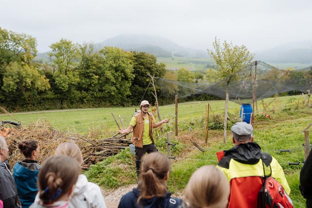 Landwirt Leander Dalbert zeigt den Anwesenden die angelegte Keyline und erklärt, wie er damit wirtschaftliche Produktion, Biodiversität und Wasserrückhaltung zusammenbringt.