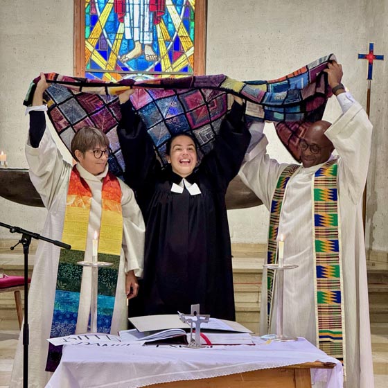 Häkeldecke mit grossem Symbolwert, hochgehalten vom Pfarrteam. Foto: Fritz Imhof