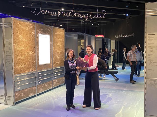 Doris Winistörfer (links), die einhunderttausendste Besucherin von «Hauptsache gesund. Eine Ausstellung mit Nebenwirkungen», bekommt Blumen von Stapferhaus-Empfangschefin Lisa Strub. Foto: Copyright: Stapferhaus