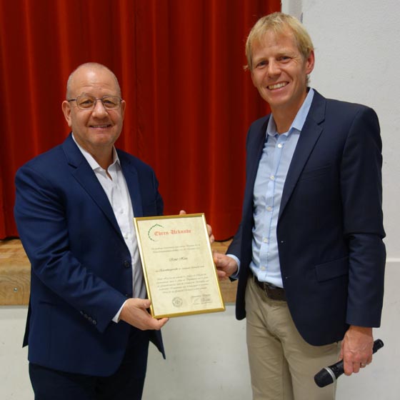 Gemeindeammann René Heiz nimmt von seinem Vize die Ehrenbürger-Urkunde entgegen. Foto: zVg