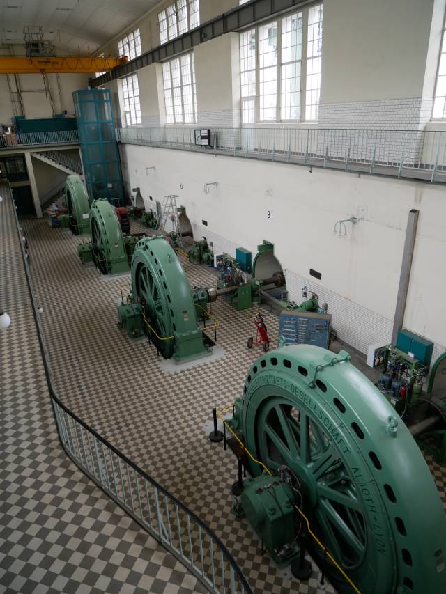 Die Kraftwerkshalle mit Generatoren, die die Fliesskraft des Wassers in Strom verwandeln und dabei Abwärme produzieren.