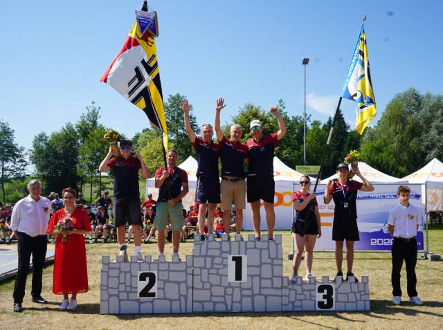Erster Rang in der Kategorie 35+ (Frauen/Männer) mit der grandiosen Punktzahl von 29.20, flankiert von den Vereinsfahnen und Hornträges des DTV und TV Wölflinswil. Foto: zVg
